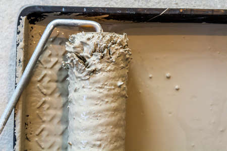 Paint roller in paint tray with grey color in the trayの写真素材