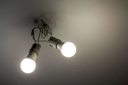 Two white electric bulbs on ceilingの写真素材