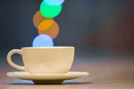 White cup of coffee with colorful bokeh steamの写真素材