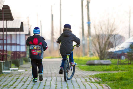 Ivano-Frankivsk, Ukraine - November 22, 2017: Boys friends on a bicycle outside. Children playing outdoorsのeditorial素材
