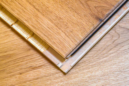 Brown wooden parquet floor planks installation , close up. Carpentry concept.の写真素材