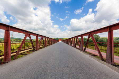Interior of metal structure of a bridge in sunny day. Perspective to infinity at the bridge in Ukraineの写真素材