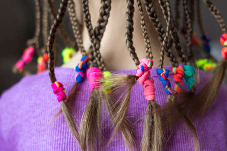 Close up of braid hair of little girl with colorful rubber bandsの写真素材