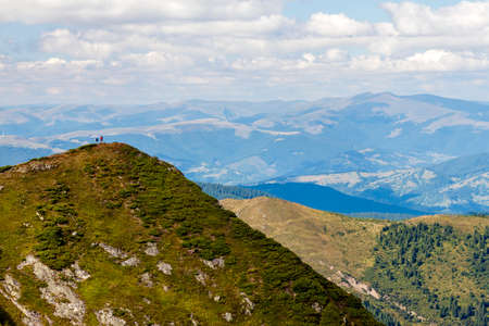 Two hikers standing on a huge mountain cliff. Hiking tourism. Power of nature concept.の写真素材