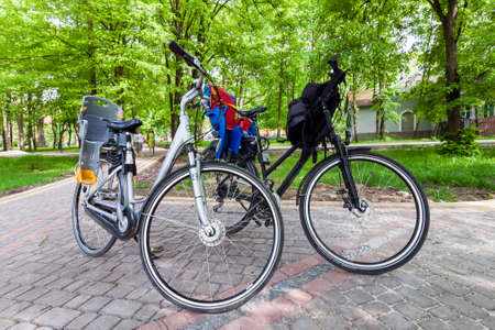 Ivano-Frankivsk, Ukraine - 29 June, 2017: Two city bicycles with baby seats in parkのeditorial素材