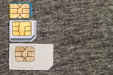 Set of mini, micro and nano simcard. Isolated on grey cloth texture background