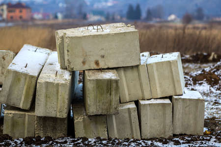 Stack of concrete blocks for foundation on construction site. Ferroconcrete reinforced with metal...