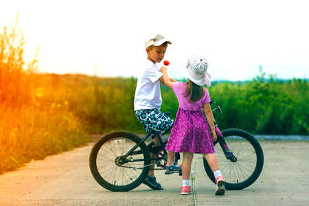 Two children in summer day bicycle and flower boy and girlの写真素材