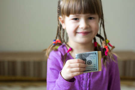 Money, finances and people concept - smiling little girl with dollar cash moneyの写真素材