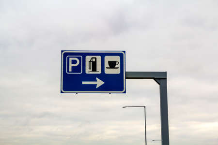 Rest area sign on a pole on freeway road. Signs for parking, gas petrol station and coffee food store.の写真素材