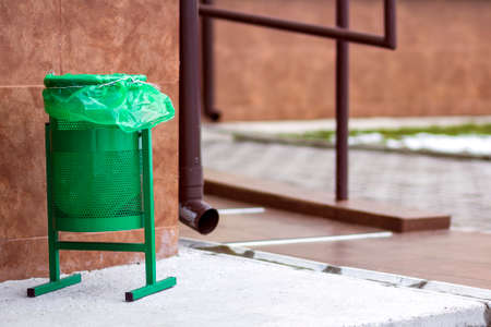 Metal green gerbage bin for rubbish. Public trash can background. Detail of outdoor infrastructure.の写真素材