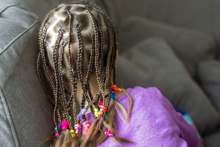 Close up of braid hair of little girl with colorful rubber bands