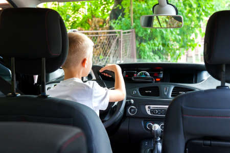 Little child boy behind the steering wheel of a carの写真素材