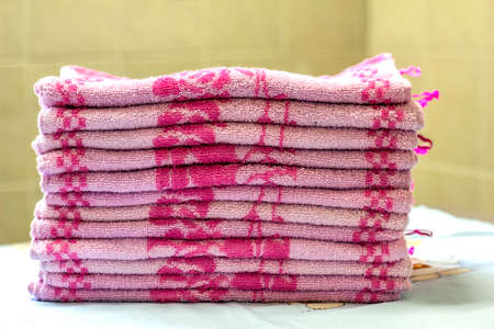 Stack of pink bath towels close-up with blurred backgroundの写真素材