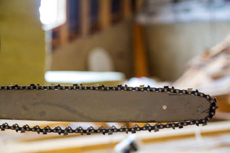 Closeup view of a chainsaw bar and cutting chain at construction site.の写真素材