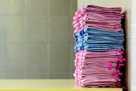 Stack of pink bath towels close-up with blurred backgroundの写真素材