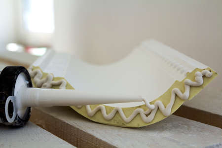 Close-up detail of decoration molding with glue adhesive before installation in interior renovation.の写真素材