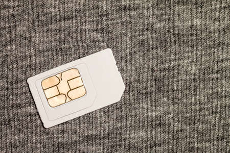 Simcard isolated on grey cloth texture backgroundの写真素材