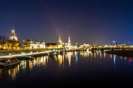 Night cityscape view of historic buildings with reflections in Elbe river in the center of Dresden (Germany).の写真素材