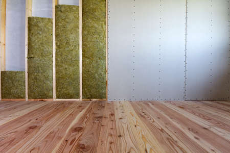 Wooden frame for future walls with drywall plates insulated with rock wool and fiberglass insulation staff for cold barrier. Comfortable warm home, economy, construction and renovation concept.の写真素材