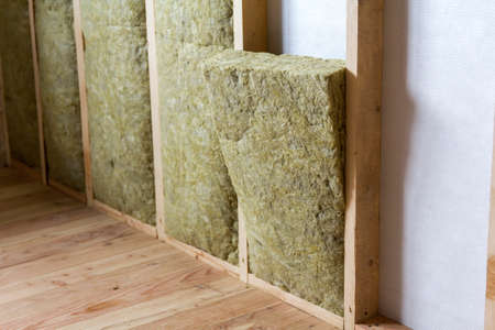 Wooden frame for future walls insulated with rock wool and fiberglass insulation staff for cold...