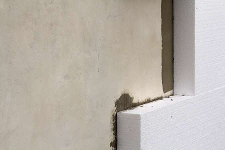 Close-up detail of plastered house wall with rigid insulation.