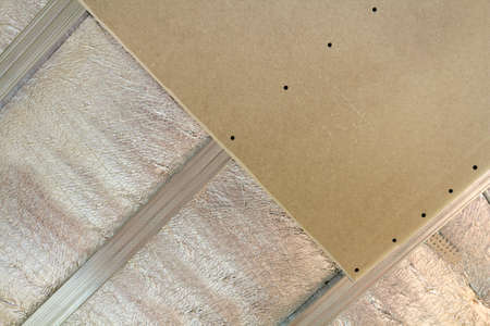 Close-up bottom view of unfinished room under construction and renovation with silver aluminum insulation foil and drywall on walls and ceiling. Professional work and renovation concept.の写真素材