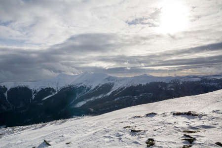 Winter mountain landscape. Wide view of distant woody mountain peaks covered with shiny snow, ice...