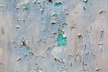 Old cracked abstract grunge vintage texture copy space background, retro pattern. White irregular spots paint peeling of light blue concrete or wooden wall or ceiling flat surface.の写真素材