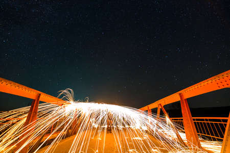 Light painting art concept. Long exposure shot of spinning steel wool in abstract circle making...