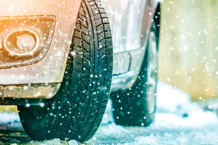 Close-up of car wheel in winter tire on snowy road