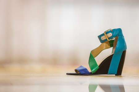 One colorful bright blue, green and yellow leather strap female shoe sandal on high black platform isolated on light copy space background. Style and fashion, modern comfortable footwear for summer.の写真素材
