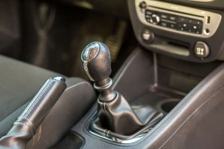 Luxurious car black leather interior. Close-up detail of handbrake manual brake and gearshift stick...