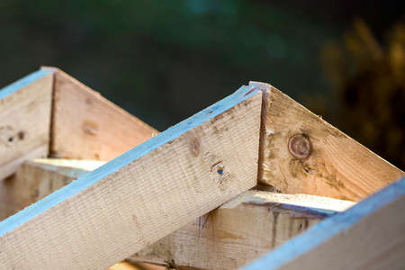 Close-up detail of roof frame of rough wooden lumber beams on background of misty mountain landscape...