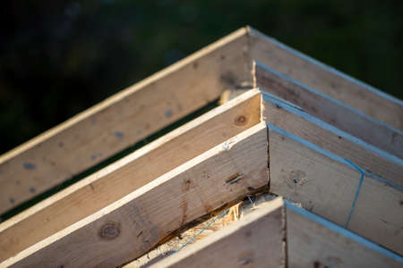 Close-up detail of roof frame of rough wooden lumber beams on background of misty mountain landscape...
