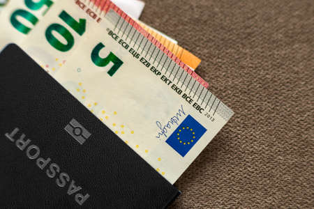 Travel passport and money, Euro banknotes bills on copy space background, top view. Traveling and  finance problems concept.の写真素材