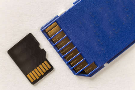 Close-up of micro SD memory card and SD adapter isolated on white copy space background. Modern...