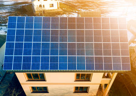 Aerial top view of new modern residential two story house cottage with blue shiny solar photo...