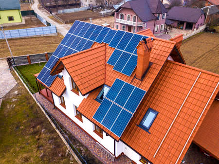 Aerial top view of new modern residential house cottage with blue shiny solar photo voltaic panels...