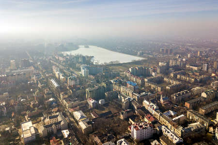 Aerial view of modern city urban foggy landscape on bright blue sky copy space background at dawn....