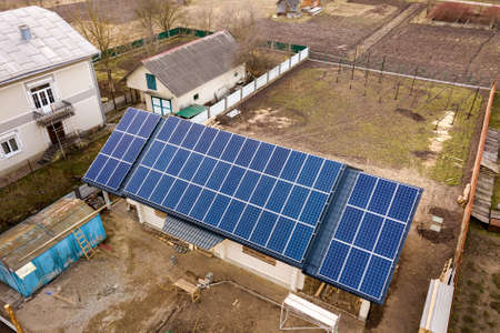 Aerial top view of new modern residential house cottage with blue shiny solar photo voltaic panels...