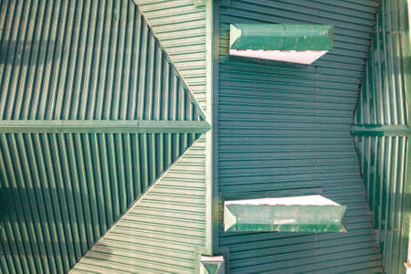 Top aerial view of building green shingle tiled roof construction. Abstract background, geometrical...