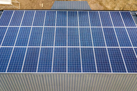 Close-up surface of blue shiny solar photo voltaic panels system on building roof. Renewable...