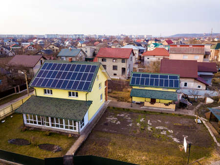 Aerial top view of new modern residential house cottage with blue shiny solar photo voltaic panels...