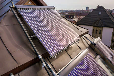 Solar water heating system on house roof. Hot water boiler, alternative ecological sun energy...