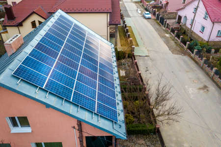 Close-up surface of lit by sun blue shiny solar photo voltaic panels system on building roof....