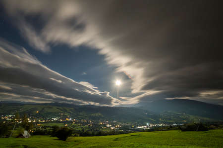 Summer Night Mountain Panorama Green Grassy Mountain Clearing Spruce Trees On Blue Evening Sky Copy Space Background Bright Road With Moving Cars And Dwelling Lights Below In Valley Royalty Free Images Photos And
