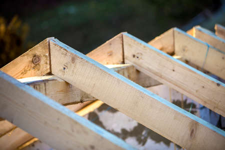 Close-up detail of roof frame of rough wooden lumber beams on background of misty mountain landscape in ecological area. Building, roofing, construction and renovation concept.の写真素材