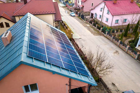 Close-up surface of lit by sun blue shiny solar photo voltaic panels system on building roof....