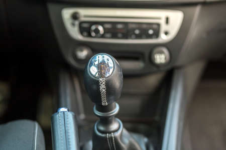 Luxurious car black leather interior. Close-up detail of handbrake manual brake and gearshift stick...